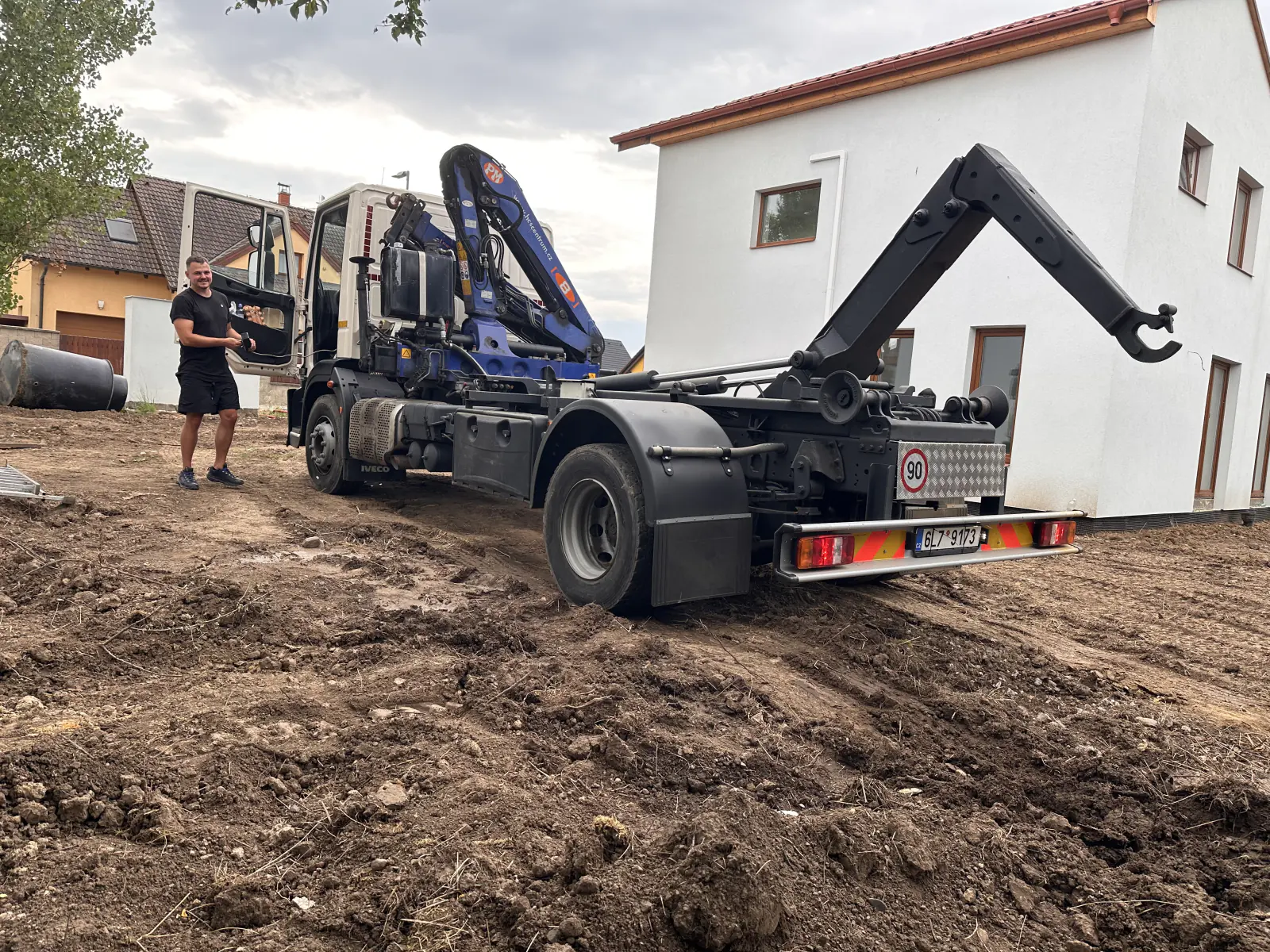 Obsluha a kontejnerové auto Kontejnerovka.cz při výjezdu u rodinného domu